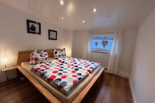 a bedroom with a bed with a floral comforter at NEU! Ferienwohnung Nestblick in Weilburg