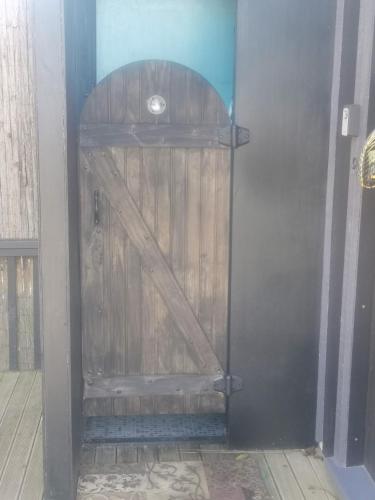 a wooden door in a room with a wooden floor at starry nights tree house in Waikino