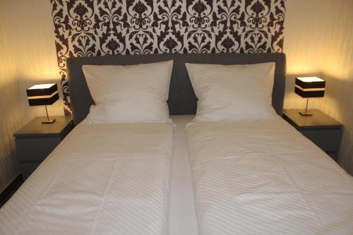 a bedroom with a bed with two pillows and two lamps at LandBrise in Petersfeld