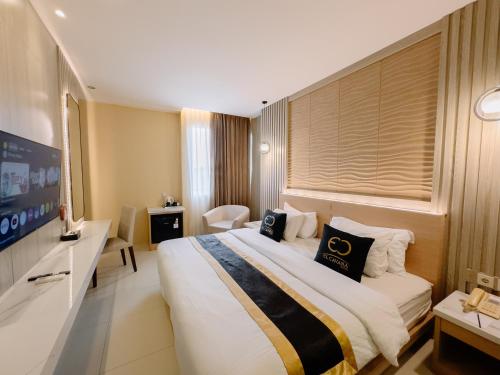 a hotel room with a large bed and a desk at El Cavana Bandung in Bandung