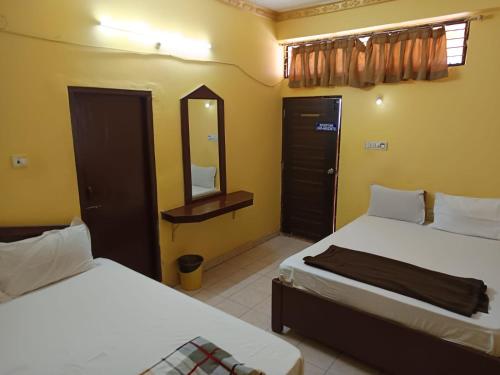 a hotel room with two beds and a mirror at PRINCE RESiDENCY HYDERABAD in Secunderabad