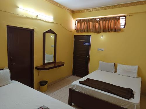 a bedroom with two beds and a mirror and a mirror at PRINCE RESiDENCY HYDERABAD in Secunderabad