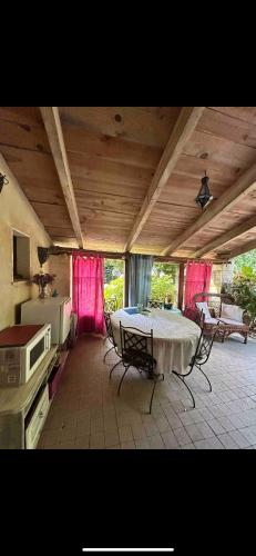 une cuisine avec une table et des rideaux roses dans une pièce dans l'établissement Chambre indépendante salle d'eau et WC privatifs, à Cézac