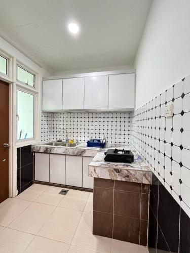 a kitchen with white cabinets and a counter top at Homestay Kubang Kerian Pinggiran Universiti HUSM, Kelantan in Kota Bharu