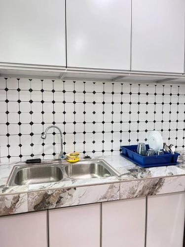 a kitchen counter with a sink and a tiled wall at Homestay Kubang Kerian Pinggiran Universiti HUSM, Kelantan in Kota Bharu