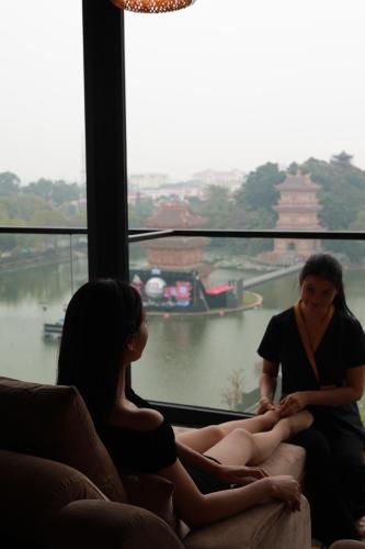 two women sitting on a couch in front of a window at Khách sạn Phố cổ Hotel Ninh Bình in Ninh Binh