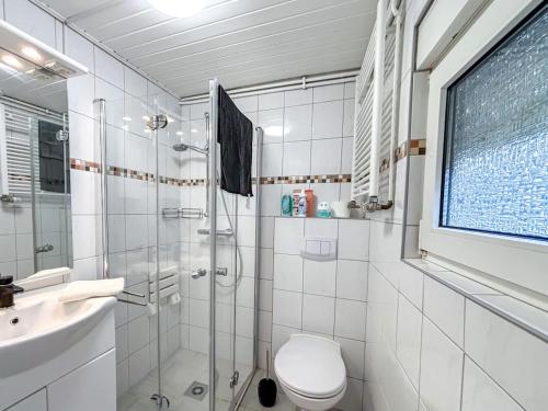 a bathroom with a shower and a toilet and a sink at Ferienhaus am Deich mit Küche, Balkon und Smart-TV in Emden