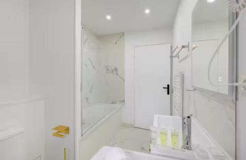 une salle de bain blanche avec un miroir et un lavabo dans l'établissement COSY Appartement Paris Centre, à Paris