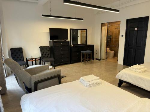 una camera d'albergo con letto, TV e sedie di Indochina Hotel - Vincom Tây Ninh a Tây Ninh