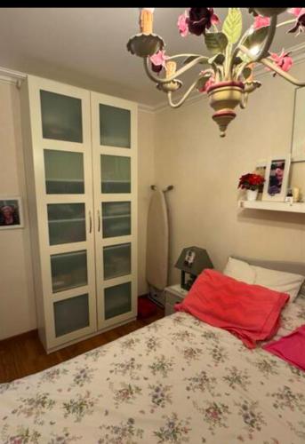 une chambre avec un lit et un lustre dans l'établissement Appartement agréable saint Brice sous forêt, à Saint-Brice-sous-Forêt