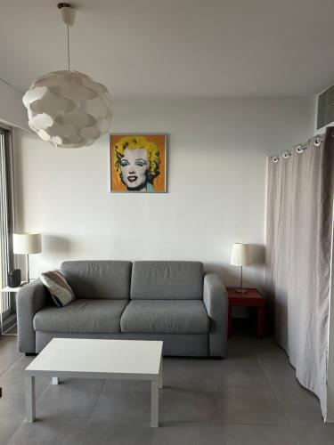 a living room with a couch and a table at T2 route des sanguinaires vue mer panoramique in Ajaccio
