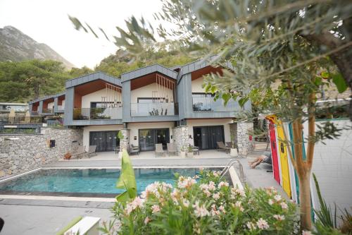 a resort with a swimming pool and a building at Ramitos Hotel in Turunc
