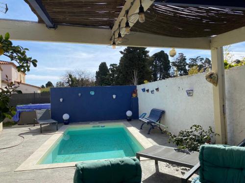 - une piscine sur une terrasse avec une table et des chaises dans l'établissement les glycines, à Villelongue-de-la-Salanque