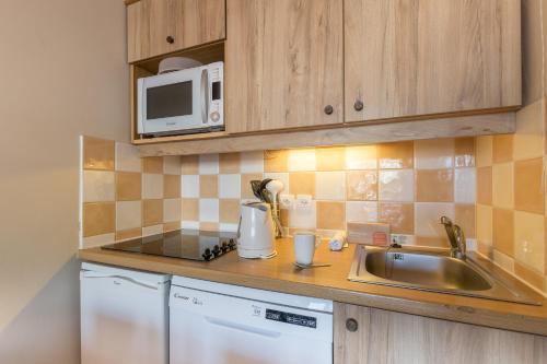 a kitchen with a sink and a microwave at Résidence Pierre & Vacances l'Albane in Vars