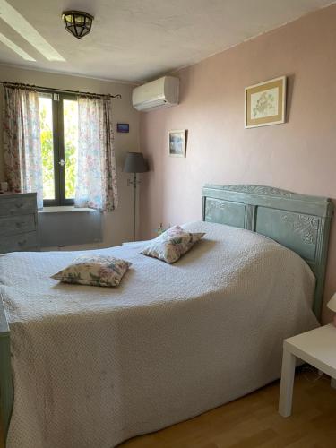 une chambre avec un lit avec deux oreillers dessus dans l'établissement les glycines, à Villelongue-de-la-Salanque