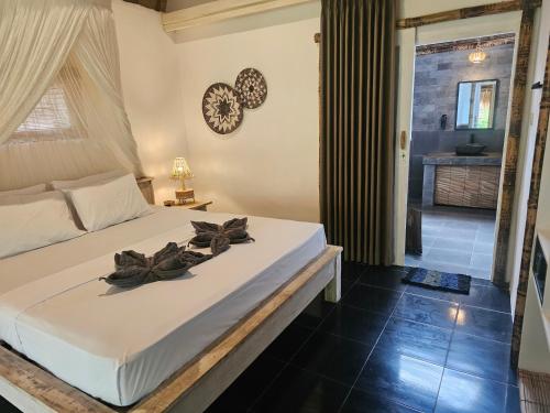 a bedroom with a bed with flowers on it at MoonBag Bungalows in Gili Air