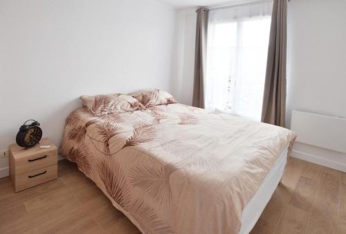 a white bedroom with a bed and a window at Apartment 5min from Disneyland Paris & Vallee Village Outlet in Magny-le-Hongre