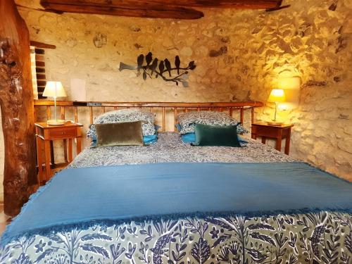 Un dormitorio con una cama en una pared de piedra. en La Tour de rêves, en Beaumont-la-Ronce