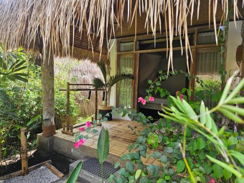 a house with a wooden deck and some plants at MoonBag Bungalows in Gili Air