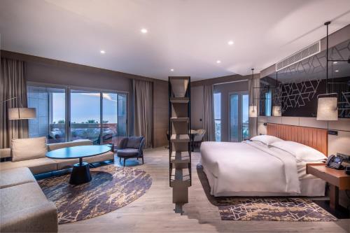 a bedroom with a bed and a living room at Sheraton Jeddah Hotel in Jeddah