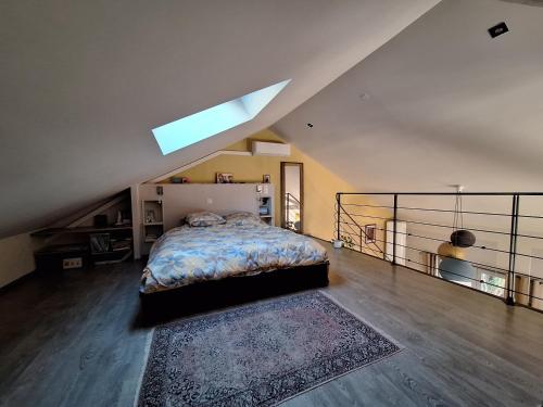 - une chambre avec un lit dans une mezzanine dotée d'une lucarne dans l'établissement La maison rose, à Avignon