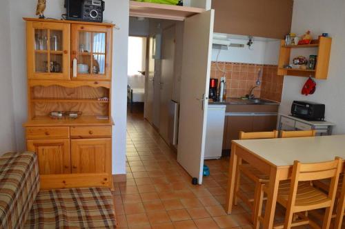 une cuisine avec une table et des chaises et une cuisine avec un comptoir dans l'établissement Appart 3 pièces - cabine 6 couchages CERBERE BN200-111, à Cerbère