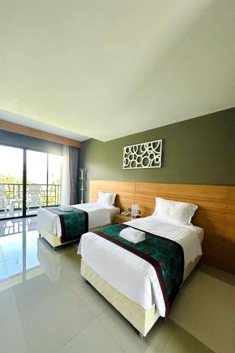 a bedroom with two beds and a balcony at The Par Phuket SHA Plus in Kathu