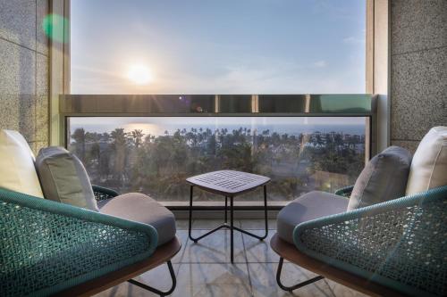 a room with chairs and a table and a large window at Sheraton Jeddah Hotel in Jeddah