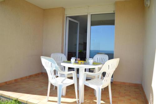 - une table et des chaises blanches sur la terrasse dans l'établissement Appart 2 pièces 4 couchages BANYULS SUR MER BN120-4215, à Banyuls-sur-Mer