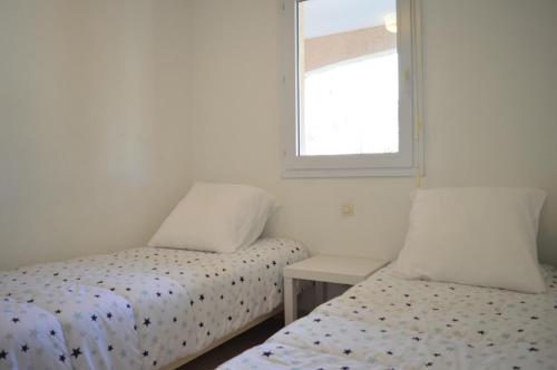 une chambre avec deux lits et une fenêtre dans l'établissement Appart 2 pièces 4 couchages BANYULS SUR MER BN120-4215, à Banyuls-sur-Mer