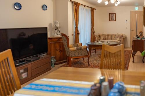 a living room with a flat screen tv and a table at 3 minutes walk to the station, direct to Ikebukuro, two-story house with a garden in Tokyo