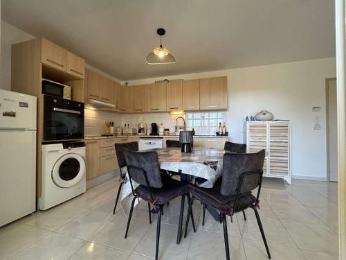 une cuisine avec une table et des chaises dans une pièce dans l'établissement Appart 3 pièces 6 couchages BANYULS SUR MER BN150-A05, à Banyuls-sur-Mer