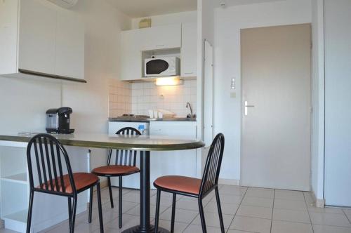 une cuisine avec deux chaises et une table avec un comptoir dans l'établissement Appart Studio - cabine 4 couchages BANYULS SUR MER BN120-3203, à Banyuls-sur-Mer