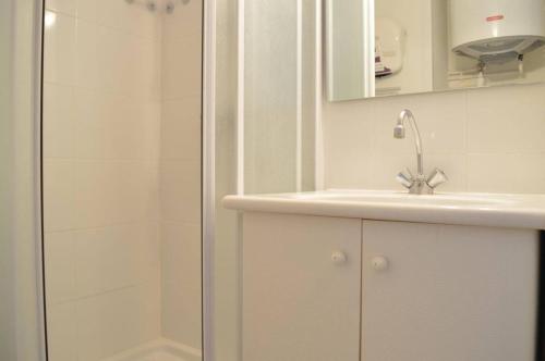 une salle de bain blanche avec une douche et un lavabo dans l'établissement Appart Studio - cabine 4 couchages BANYULS SUR MER BN120-3203, à Banyuls-sur-Mer
