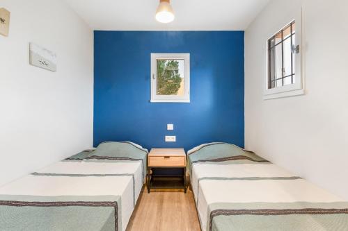 - 2 lits dans une chambre avec un mur bleu dans l'établissement Port Lano - Joli T3 à Agde, au Cap d'Agde