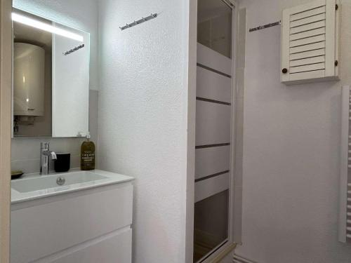 une salle de bain blanche avec un lavabo et un miroir dans l'établissement Appart studio 2 couchages BANYULS SUR MER BN030-E02, à Banyuls-sur-Mer