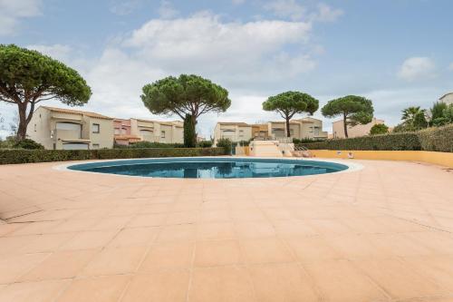 une piscine au milieu d'une cour arborée dans l'établissement Port Lano - Joli T3 à Agde, au Cap d'Agde