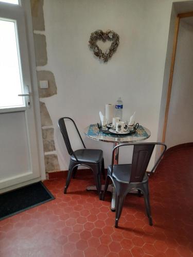 - une table avec deux chaises et une plaque de cuisson dans l'établissement La Tour de rêves, à Beaumont-la-Ronce