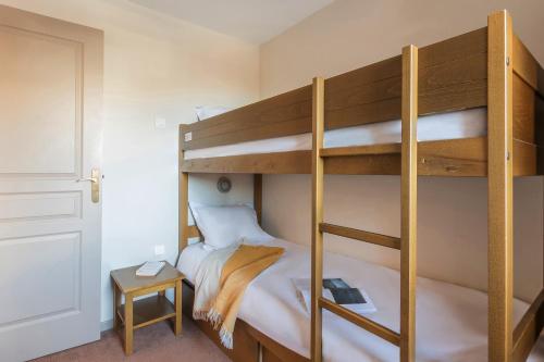 a bedroom with two bunk beds and a table at Résidence Pierre & Vacances l'Albane in Vars