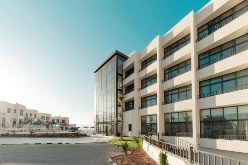 an office building with a street in front of it at Diamond Palm Hotel & Resort in Al Burj