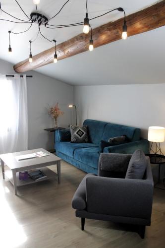 un salon avec un canapé bleu et une table dans l'établissement Appartement duplex centre historique avec patio, à LʼIsle-sur-la-Sorgue