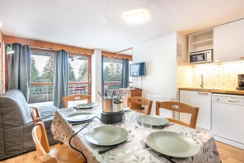une cuisine et une salle à manger avec une table et des chaises dans l'établissement Joubarbes - Station à pied, à Chamrousse