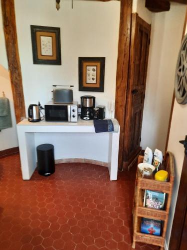 - une cuisine avec une table blanche et un four micro-ondes dans l'établissement La Tour de rêves, à Beaumont-la-Ronce