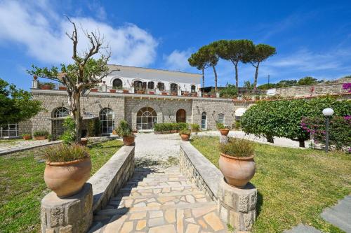 a stone building with potted plants on pillars at Tenuta Villa Tara in Sant'Angelo D'Ischia