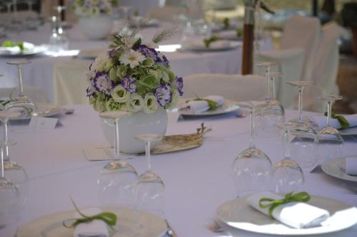 a table with wine glasses and a vase of flowers at Masseria Valente in Ostuni