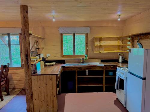 a small kitchen with a refrigerator and a stove at Maccys Cottages in Macclesfield
