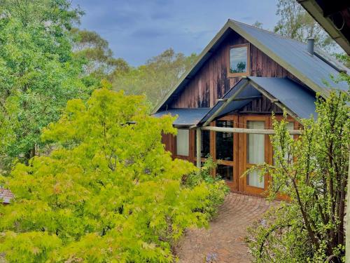 a house with a blue roof and some trees at Maccys Cottages in Macclesfield