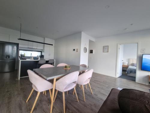 a dining room and living room with a table and chairs at Luxurious stay at Doncaster East in Doncaster East