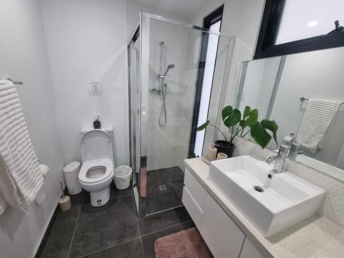 a bathroom with a toilet and a sink and a shower at Luxurious stay at Doncaster East in Doncaster East