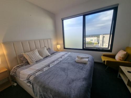 a bedroom with a large bed with a large window at Luxurious stay at Doncaster East in Doncaster East